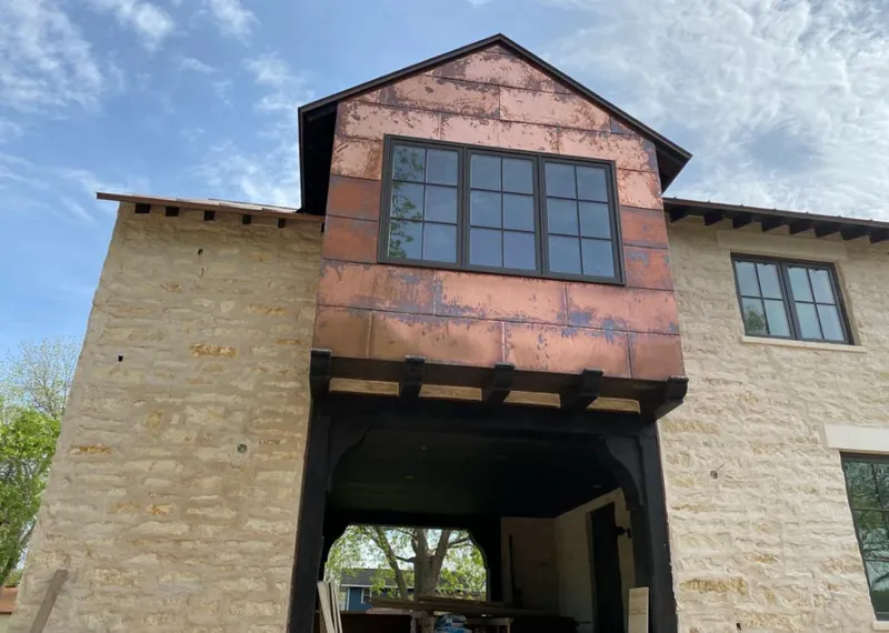 Copper metal panel facade on a stone building for Skylight Installation in Middle Valley